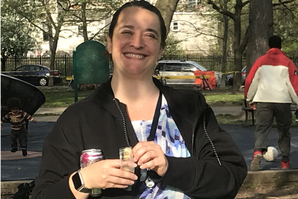 A member of the herbert lab at the parking outing smiling and snacking.