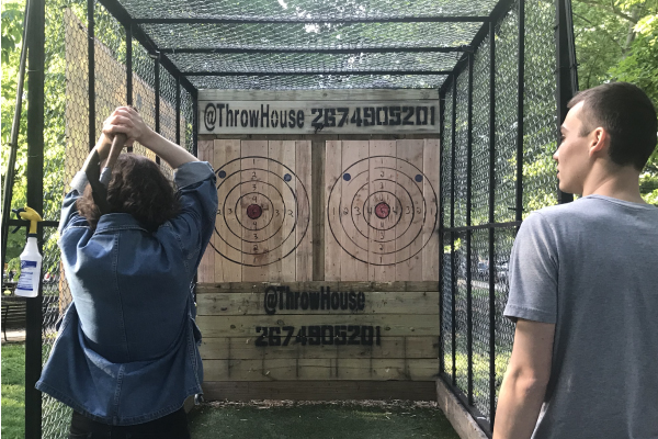Two members of the herbert lab throwing axes at the throw house event.